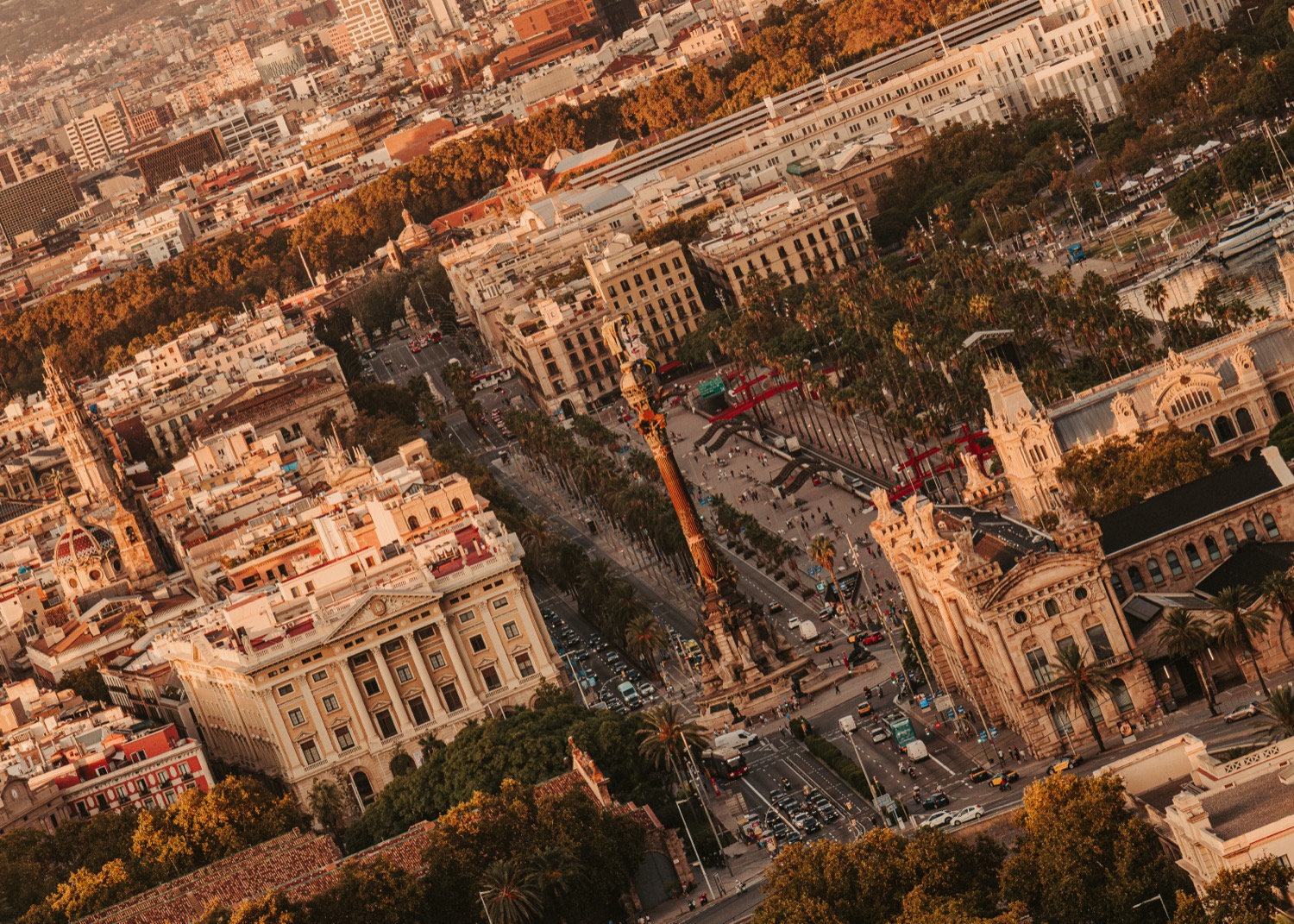 Aerial view of Barcelona at golden hour, looking down on the Columbus Monument